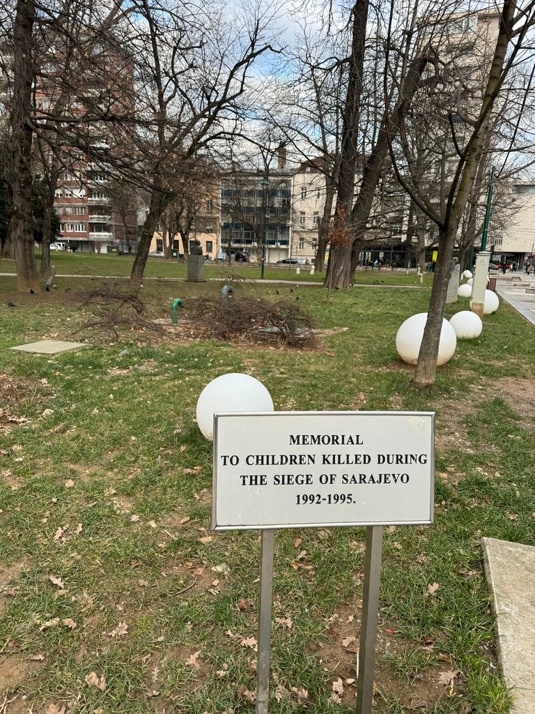 After landing and entering the city, the mood is extended by viewing a memorial to children killed during said ethnic cleansing.