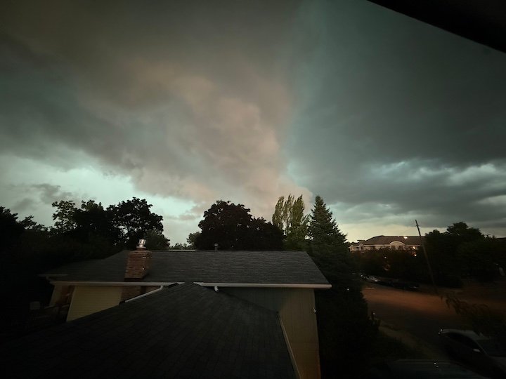 Rooftops with ominous clouds that remind you to call your mother